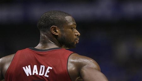 Miami Heat's Dwyane Wade pauses during a break in play against the Dallas Mavericks during Game 3 of the NBA Finals basketball series in Dallas