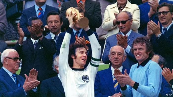 بكنباور قائد منتخب ألمانيا يرفع كأس العالم لعام 1974 في ميونيخ وبجواره زميله الحارس العملاق سيب ماير 