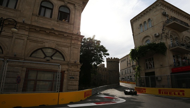 صورة لسيارة فورمولا 1 تمر بمحاذاة سور المدينة القديمة في مسار ضيّق