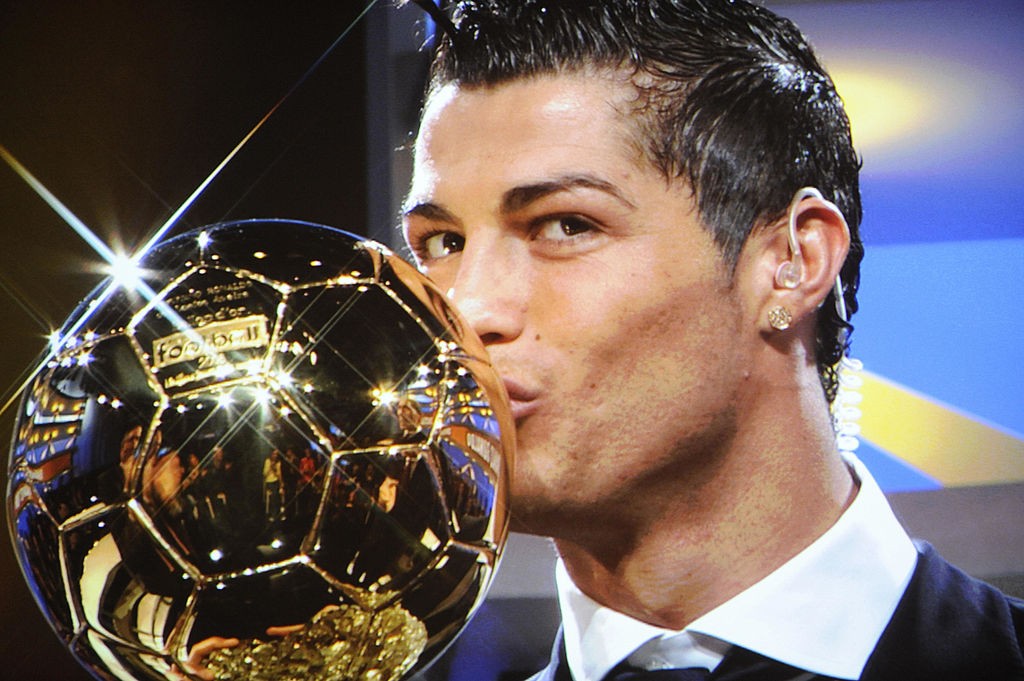 A photo taken on a TV screen shows Manchester United Portuguese winger Cristiano Ronaldo kissing his trophy on a French TV set after he won the European footballer of the year award, the "Ballon d'Or" (Golden ball), on December 7, 2008 in Boulogne-Billancourt, outside Paris. Ronaldo beat Barcelona's Lionel Messi and Liverpool striker Fernando Torres to the honour on the back of a phenomenal 2007-08 season in which he scored 42 goals for his Premier League and Champions League-winning club. Ronaldo becomes the first United player to win the award since the late George Best in 1968. AFP PHOTO FRANCK FIFE (Photo credit should read FRANCK FIFE/AFP via Getty Images)